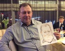 Валерий держит свой шарж в ресторане 