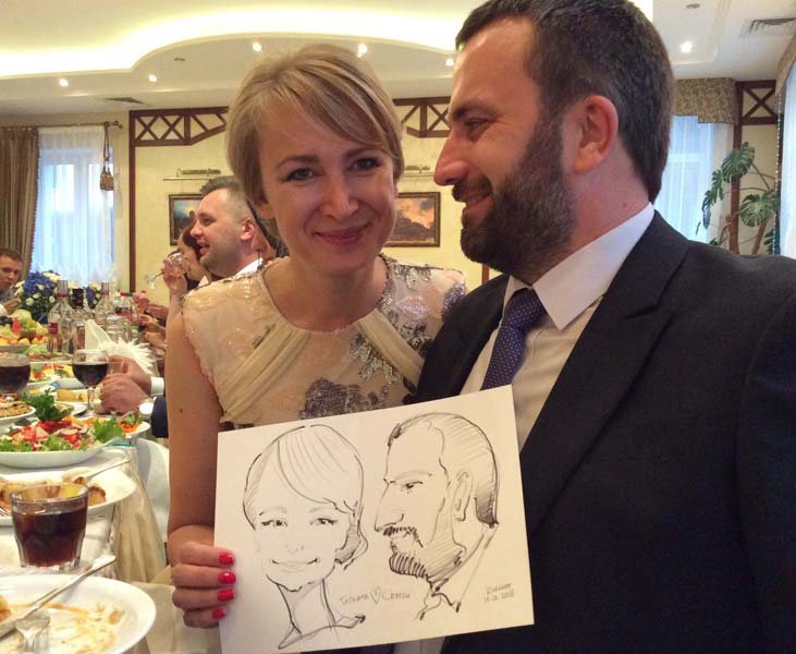 Татьяна и Сергей позируют шаржисту Михаилу Шабалину